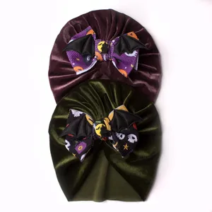 Detail of Halloween baby turban hats in purple and green velvet with bat wing bows