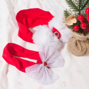 Détail de bandeaux de Noël rouges pour bébé avec pompons et nœuds à paillettes