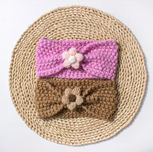 Dettaglio di due fasce per neonati lavorate a mano con fiori all'uncinetto su stuoia
