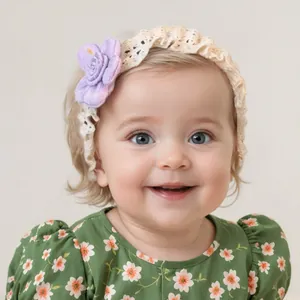 Detail view of baby girl wearing a lace elastic headband with a soft purple floral accent