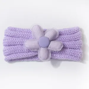 Detailed close-up of a soft purple knitted baby headband with a large 3D floral decoration