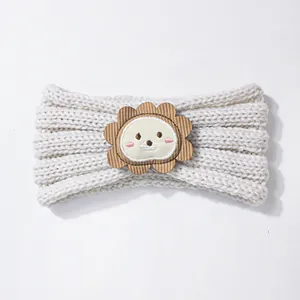 White cable knit baby headband featuring a cute cartoon lion patch for winter warmth