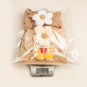 Three-piece baby floral headband set on a scale showing 101.6g weight for shipment