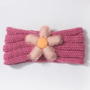 Detail of baby knitted headband featuring a pink checkered flower and knit texture