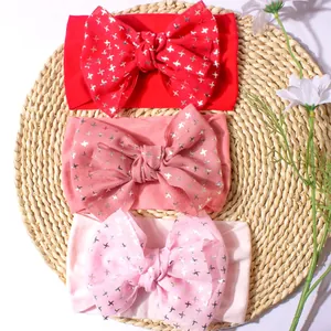 Lot de trois bandeaux bébé en nylon souple avec grands nœuds pailletés sur tapis