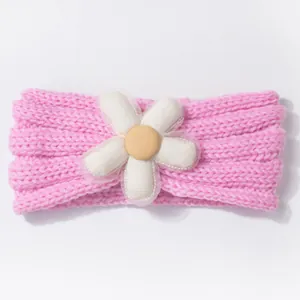 Close-up of pink knitted baby headband with a decorative white fabric flower