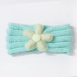 Detail of mint green knitted baby headband featuring a mesh lace fabric flower