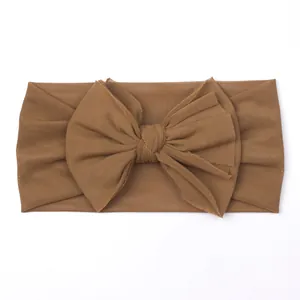 Detail of baby wide bow headband in brown mesh fabric with soft elastic texture