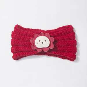 Detail of red knit baby headband featuring a cute lion patch and ribbed texture