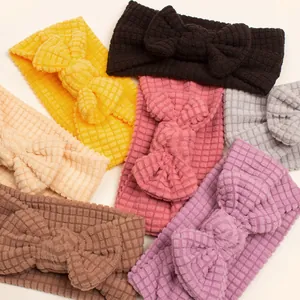 Detailed macro view of seven colorful waffle-knit infant headbands with large bows