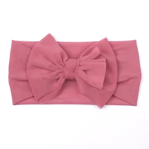 Close-up of baby mesh headband with a large handmade bow in dark pink color