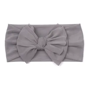 Detail of soft grey mesh baby headband featuring a large delicate layered mesh bow