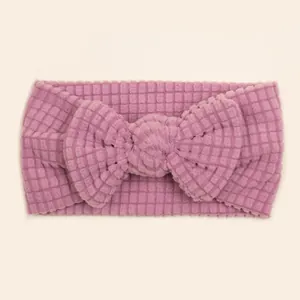 Detail of baby headband featuring purple waffle knit texture and a large soft bow