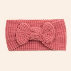 Close-up of pink waffle texture fabric on baby headband with decorative bow detail