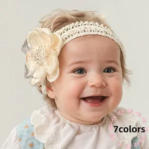 Schattige baby haarband van kant met een grote crème bloem en parel details