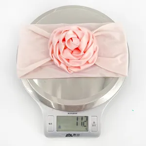 Détail du bandeau bébé rose avec rose en satin pesant seulement 11,2g sur la balance