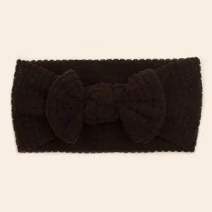 Detail of dark coffee waffle knit baby headband featuring a large soft textured bow