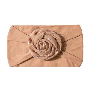 Close-up of baby nylon headband with silver bird print rose knot in light brown fabric