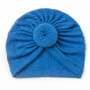 Close-up of royal blue knitted baby turban featuring a decorative donut-shaped knot