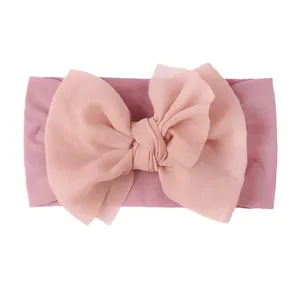 Detail of pink nylon baby headband featuring a large double-layer chiffon bow decoration