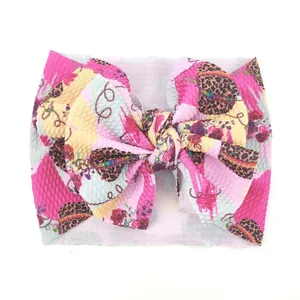Detalle de diadema para bebé con estampado floral de leopardo y lazo de tela gofrada