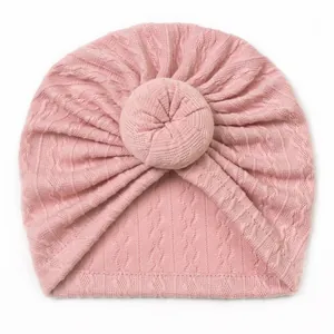 Detailed knit texture of pink baby turban hat with a stylish soft donut knot design