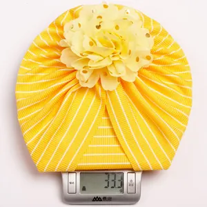 Detailed close-up showing the lightweight 33.3g striped baby hat with a gold-dot flower