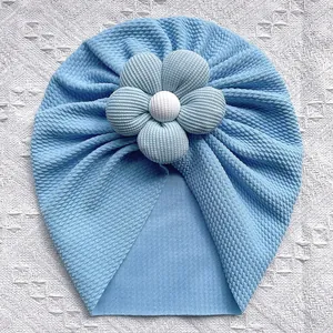 Bonnet turban bébé bleu clair en maille gaufrée avec grande fleur sur dentelle blanche