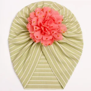 Close-up of green striped baby turban hat with a large pink gold-dotted chiffon flower