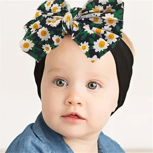 Gros plan d'un bandeau bébé noir doux avec un grand nœud à imprimé marguerites blanches