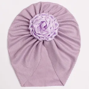 Detail of purple ribbed knit baby turban with a large handmade satin rose flower decor