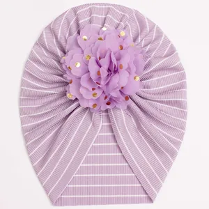 Detailed macro view of baby turban hat with purple stripes and large chiffon gold foil flower