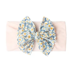 Détail du bandeau élastique pour bébé avec ruban rose et nœud papillon à motif floral doux