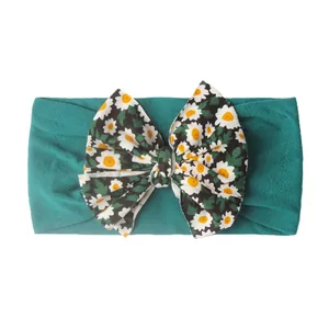 Détail du bandeau élastique pour bébé sarcelle avec nœud imprimé marguerite sur blanc