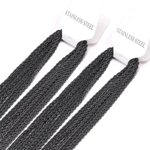 Détail macro de chaînes torsadées en acier inoxydable noir sur cartes blanches