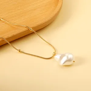 Golden snake chain necklace with small beads and a large white baroque pearl pendant