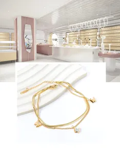 Detail eines goldenen Doppel-Fußkettchens mit Zirkonia-Schmetterlingen und Texturierung