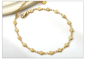 Detailed macro of gold flower link anklet with S.Steel heart tag on stone tray