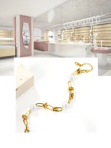 Detailansicht eines goldfarbenen Kettenarmbands mit großen Perlen und Knotendesign