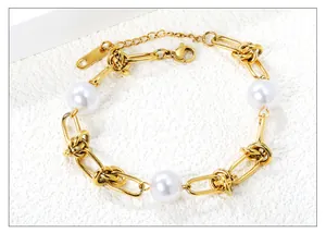 Detailansicht eines goldenen Gliederkettenarmbands mit drei Perlen und Karabinerverschluss