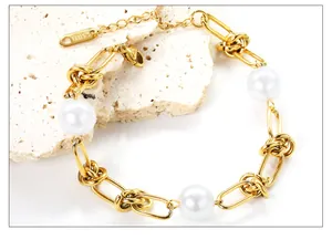 Makro-Detail von 18k vergoldeter Edelstahlkette mit weißen Perlen und einem Karabinerhaken