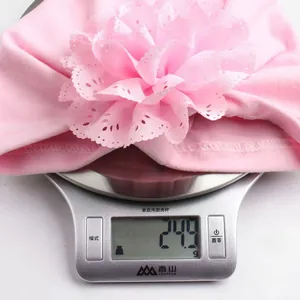 Detailed shot showing a 24.9g lightweight pink baby turban with a delicate lace flower