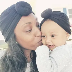 Mom and baby matching black donut turban hats in soft knit fabric for warmth