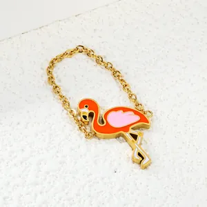 Golden flamingo pendant with vibrant orange and pink enamel finish for bags or keys