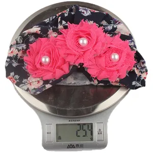 Detail shot of a lightweight baby floral turban weighed on a digital scale at 25.4g