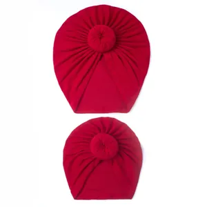Detail of red donut knot baby turban hats with soft pleated knit fabric texture