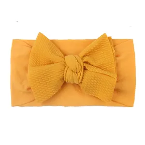 Elastic baby nylon headband with large mustard yellow waffle texture bow decoration