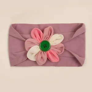 Dettaglio fascia per neonati in nylon con fiore in tessuto e bottone verde centrale