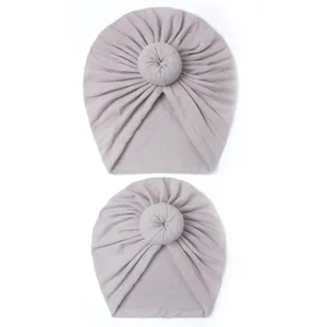 Detail of grey parent-child donut hats featuring soft knitted cotton and top knot design