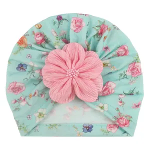 Detail der Baby-Turbanmütze mit Blumenmuster und einer großen rosa perlenbesetzten Blume